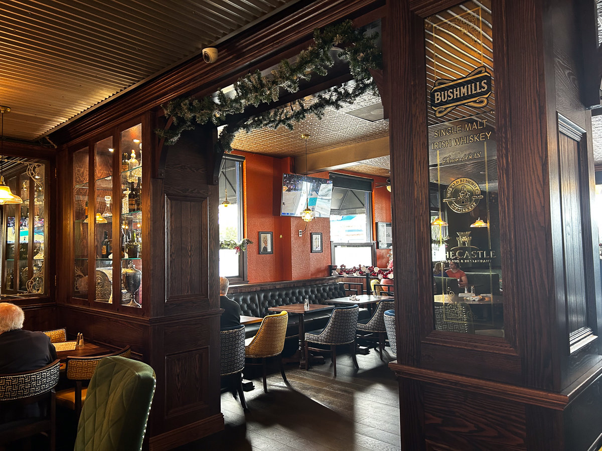 room with dark wood walls and pillars with a private seating space
